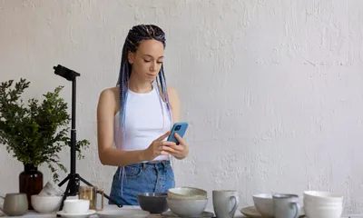 Dono de negócio produzindo conteúdo para redes sociais com celular