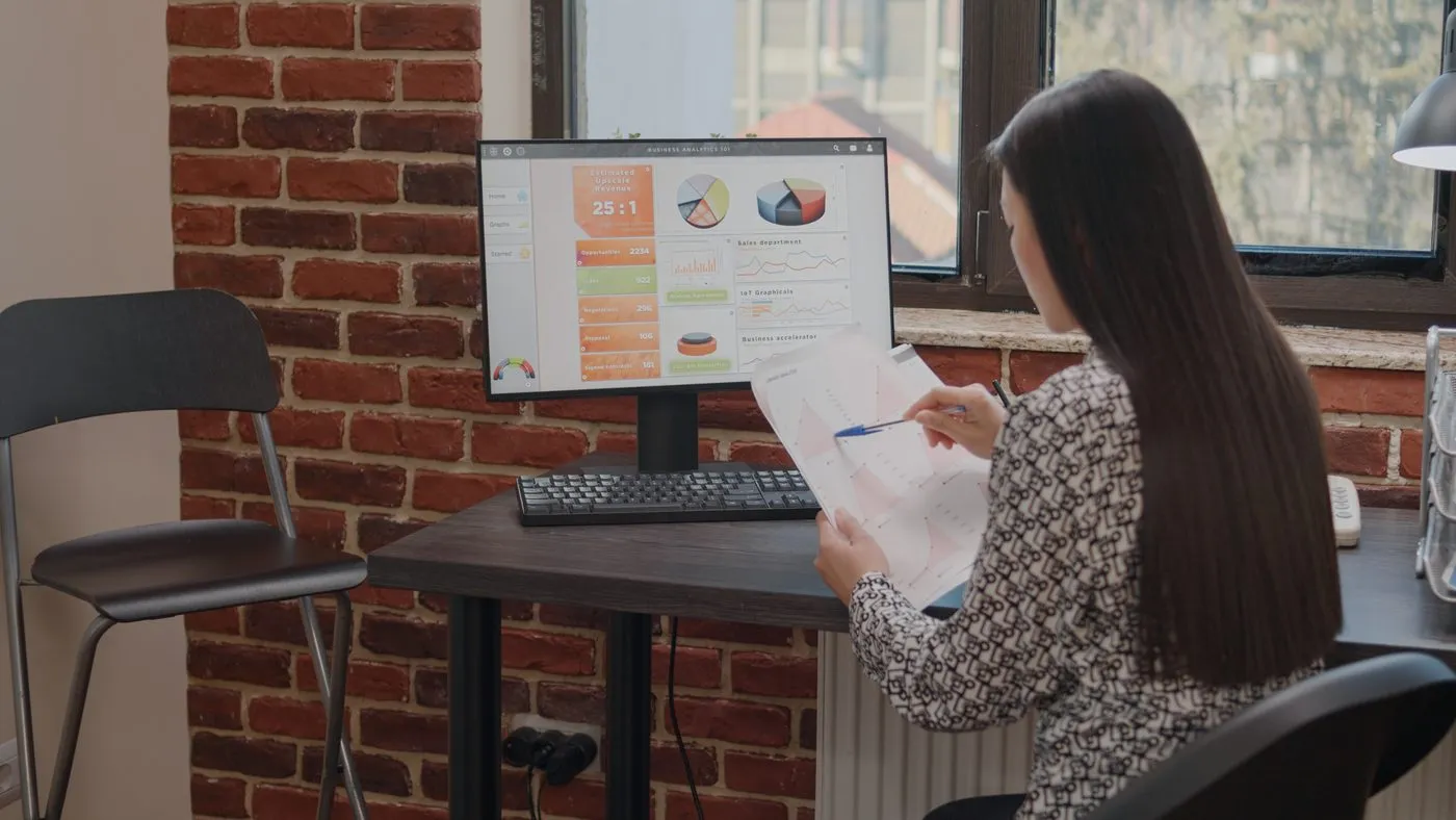 Pessoa analisando gráficos e planilhas de dados de clientes